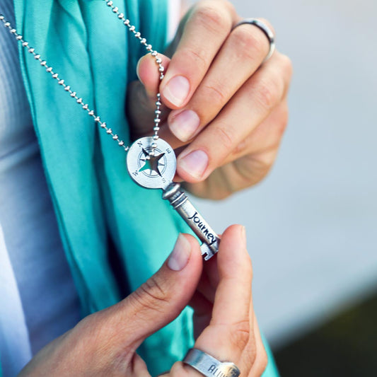 person holding journey key on a necklace