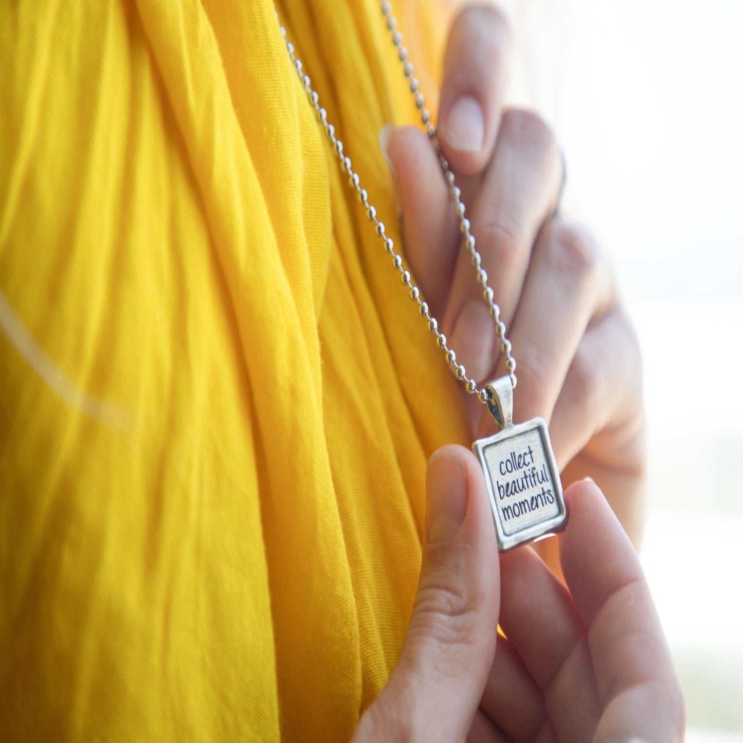 Person holding Collect Beautiful Moments Necklace