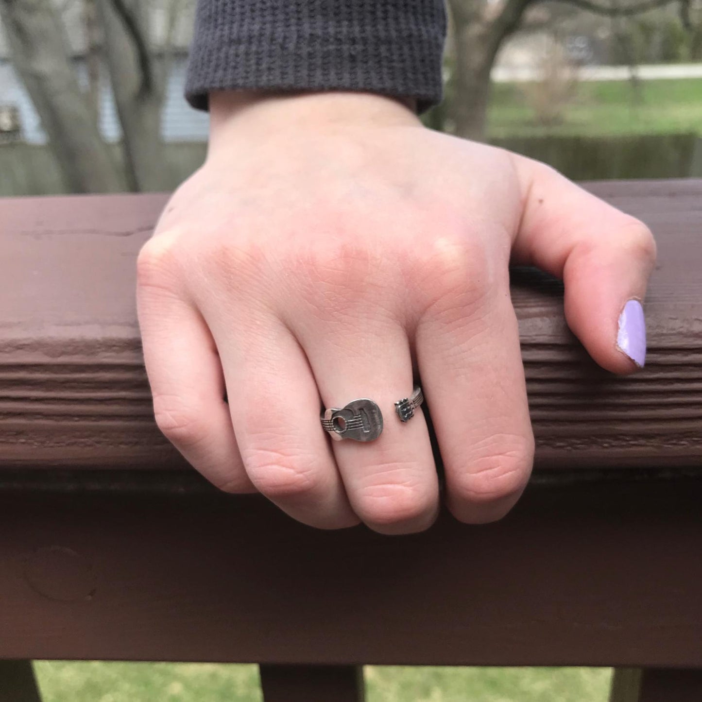 Guitar Player Inspire Ring on finger gripping banister