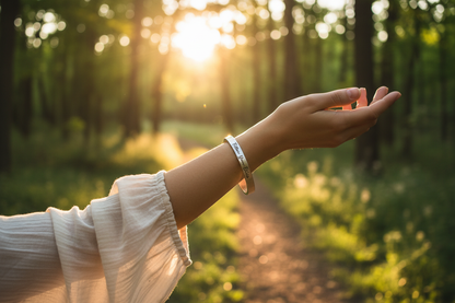 Follow Your Bliss open cuff bracelet worn on wrist outdoors in golden hour light
