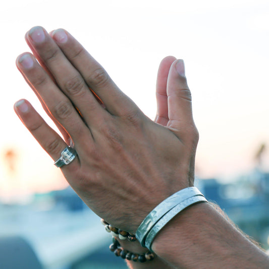 person with hands together wearing rings and braclets