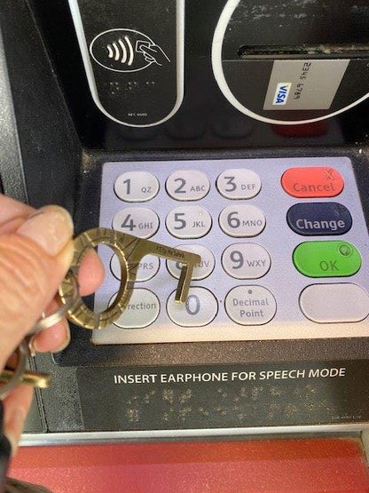 Person using KEYp Me Safe Germ Key to press ATM buttons