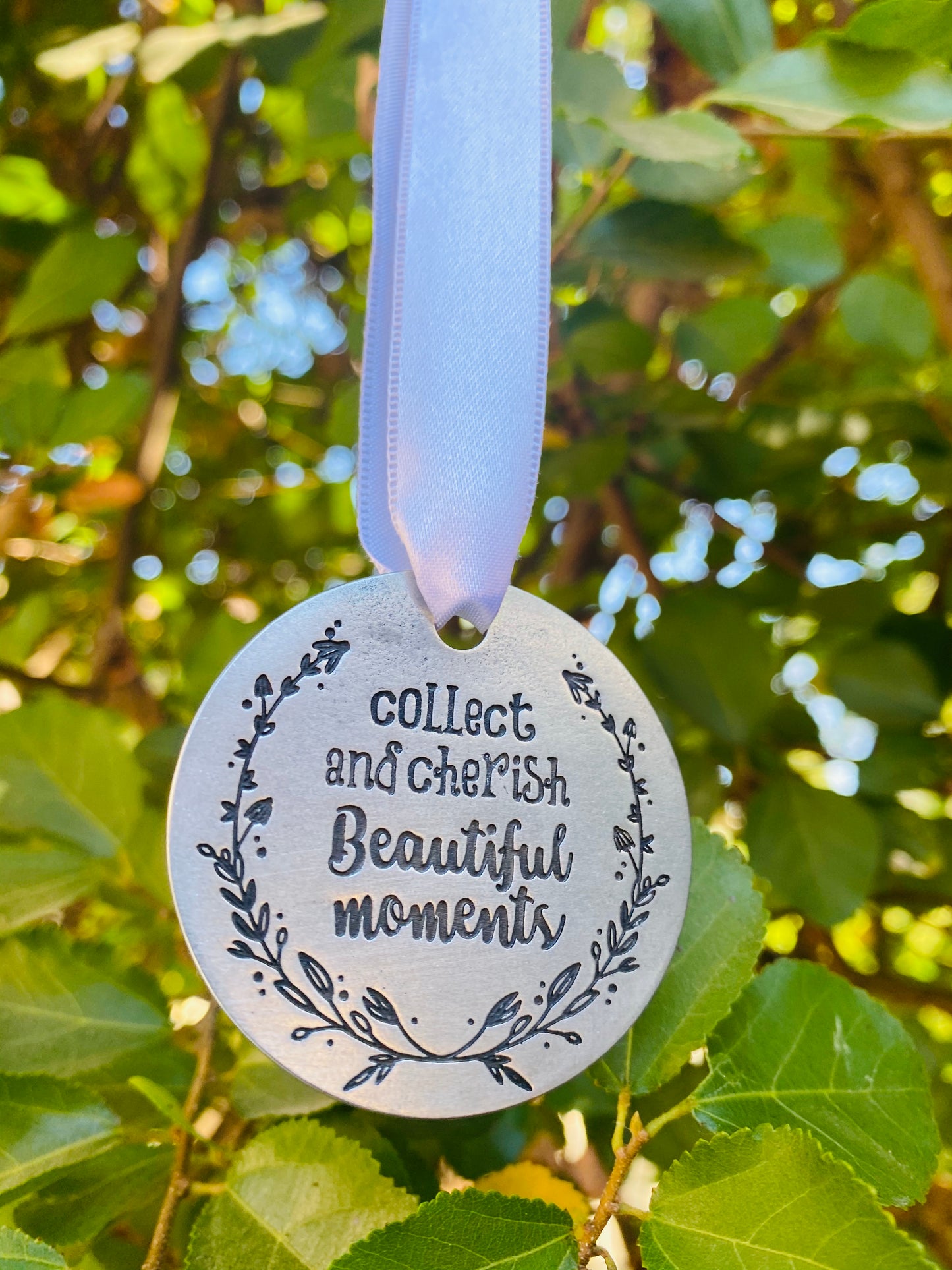 Collect and Cherish Beautiful Moments Holiday Ornament hanging in a tree