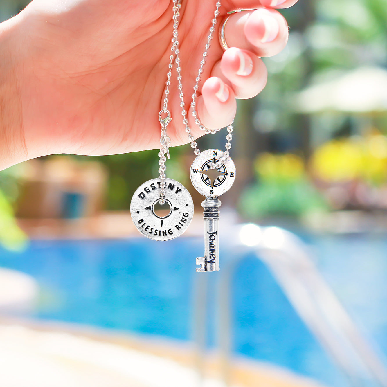 Hand holding Journey Key Charm on ball chain