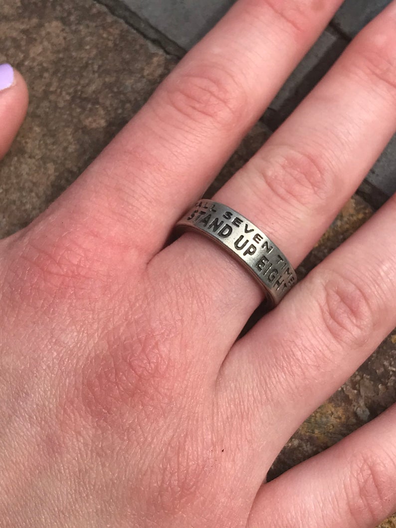 Fall Seven Times, Stand Up Eight Inspire Ring on finger